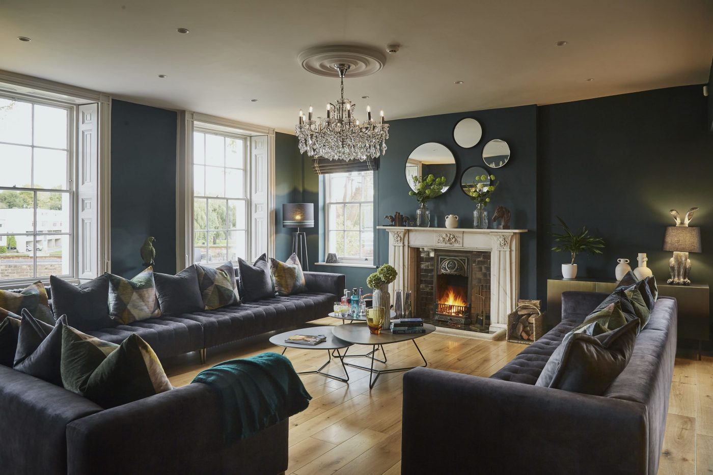 Open plan living area of Edgar House in Chester, Two large sofas with a coffee table and fire place